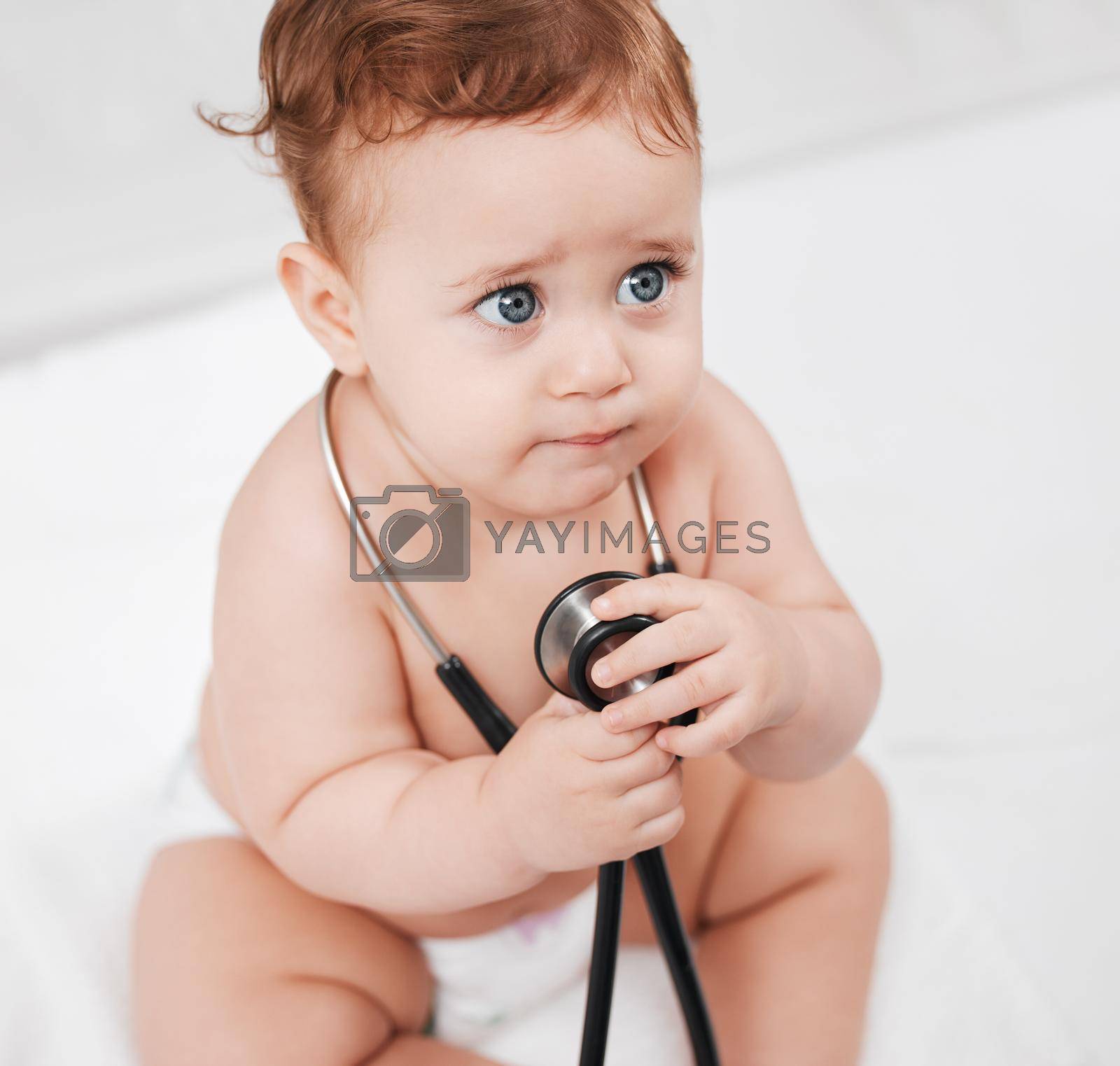 Royalty free image of Erm, lady doctor will this hurt. an adorable little baby boy hold a stethoscope in a clinic during his checkup. by YuriArcurs