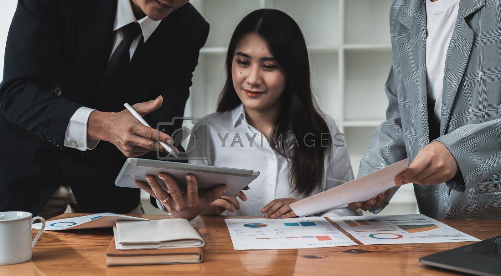 Royalty free image of Business team are meeting and discussing marketing plan and pointing graph report analyzing financial figures denoting the progress in the work by nateemee