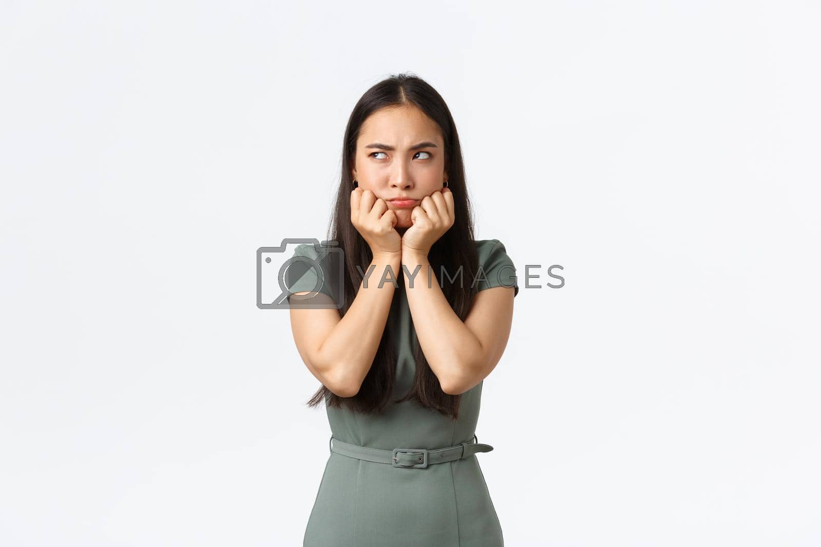 Royalty free image of Small business owners, women entrepreneurs concept. Pouting moody asian girlfriend acting childish as looking left offended, sulking over argument or confrontation with boyfriend, white background by Benzoix