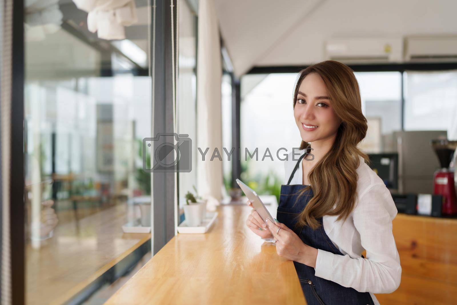 Royalty free image of Portrait of asian barista cafe owner with tablet to check order sme entrepreneur seller business concept. by itchaznong