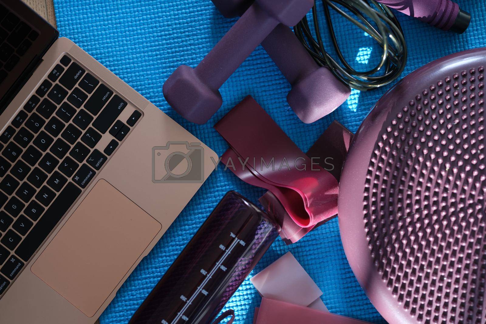 Royalty free image of Laptop with purple sports equipment on sports mat top view by kuprevich