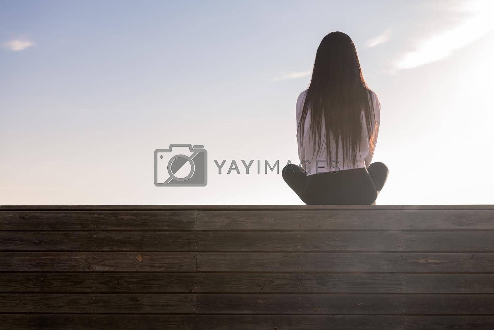 Royalty free image of rear view of a woman with long hair meditating by raulmelldo