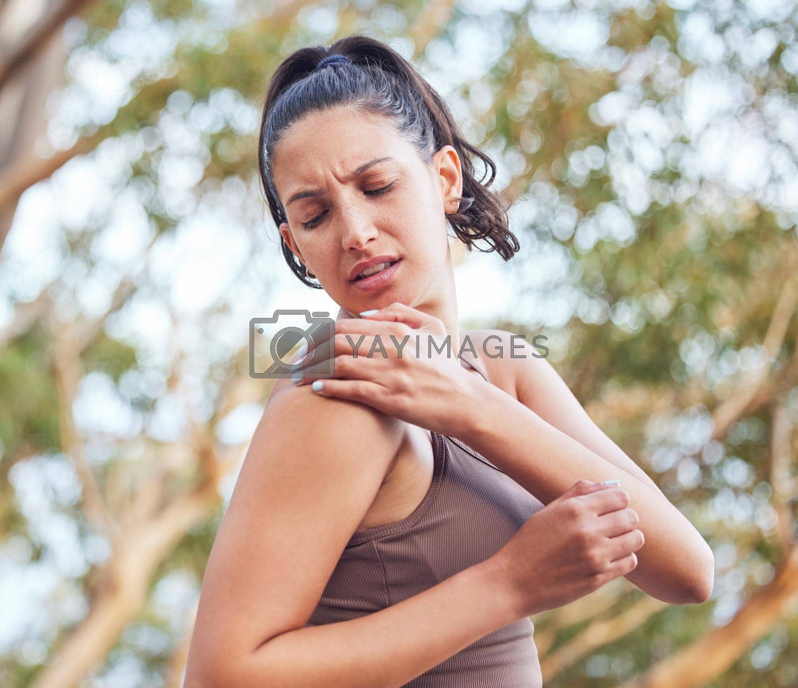 Royalty free image of This muscle suddenly pulled stiff. a young woman experiencing shoulder pain while exercising outdoors. by YuriArcurs