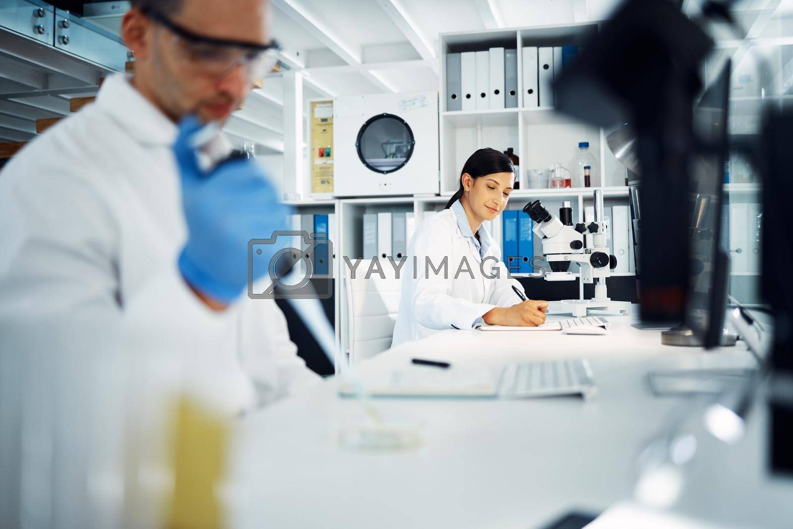 Royalty free image of From the lab to the pharmacy. a young scientist writing notes while conducting medical research in a laboratory. by YuriArcurs
