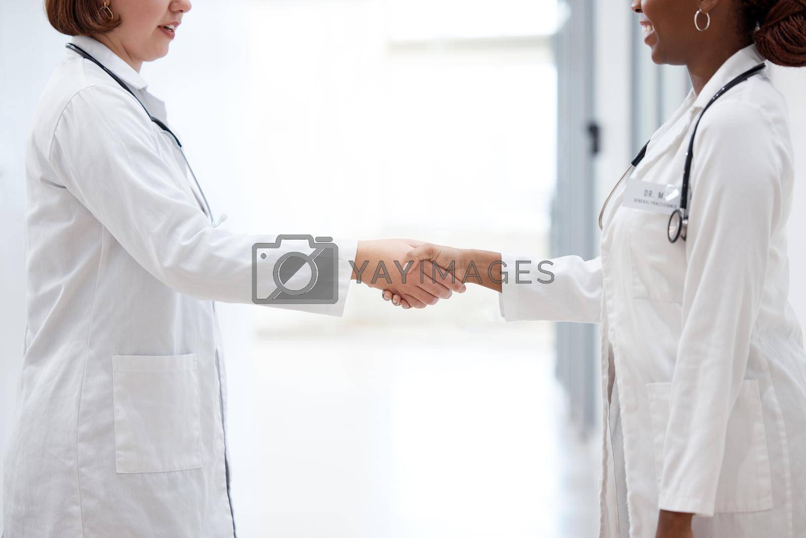 Royalty free image of Welcome to the team. two doctors shaking hands in meeting. by YuriArcurs