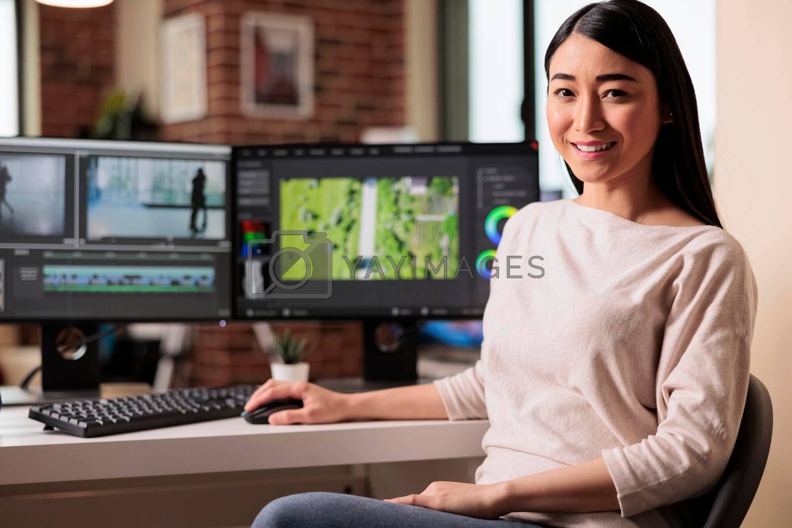 Royalty free image of Portrait of female videographer editing movie footage by DCStudio