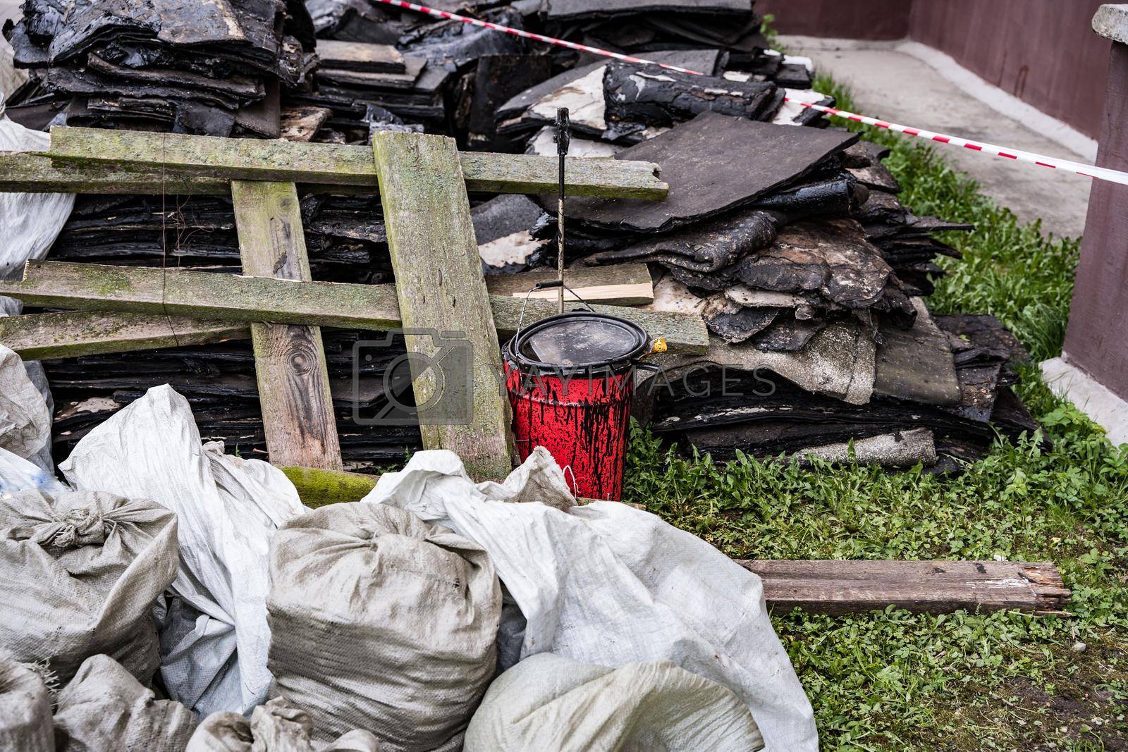 Royalty free image of debris left after the repair of the roof. red bucket with mastic by audiznam2609