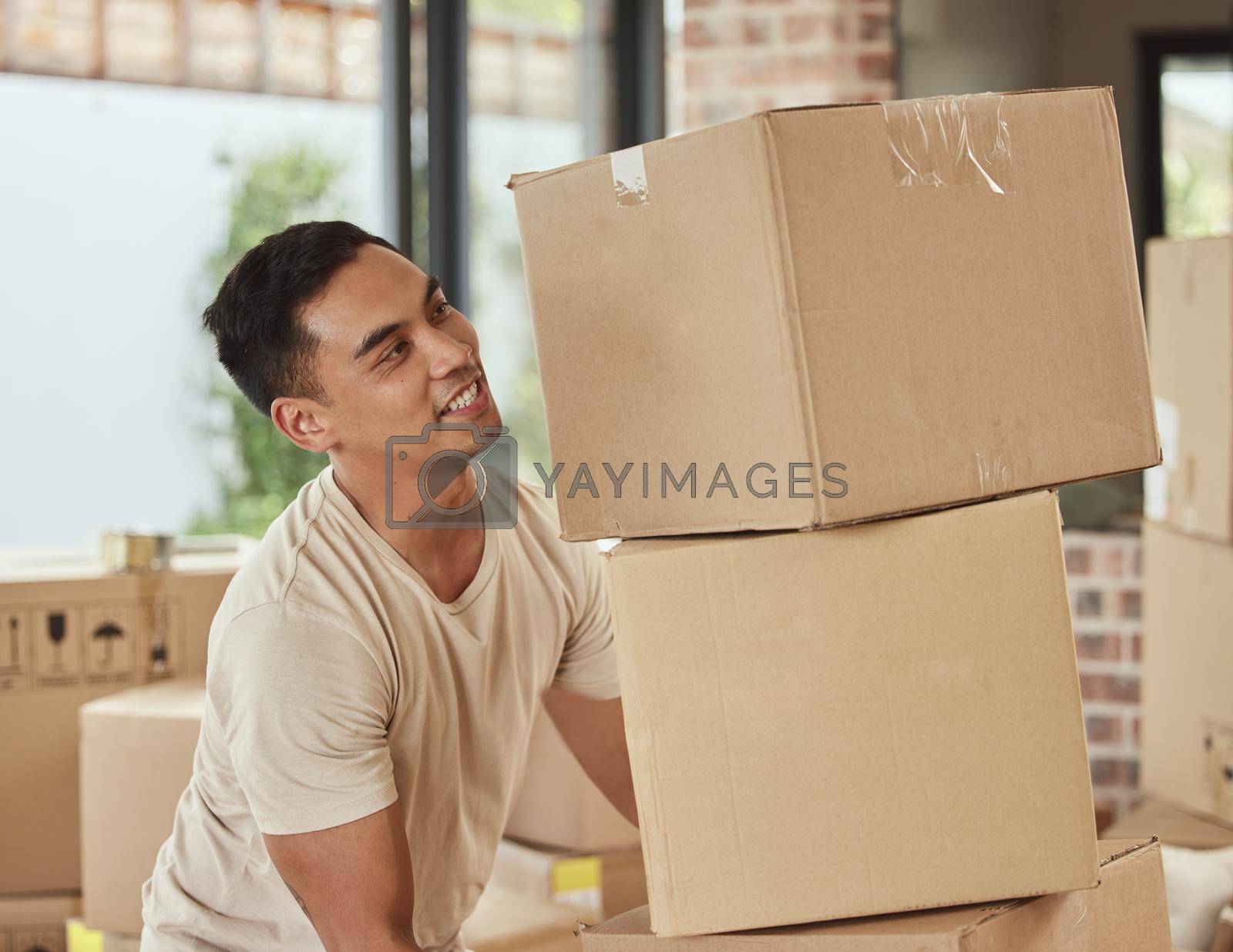 Royalty free image of Getting settled into his new home. a man carrying boxes into his new home. by YuriArcurs