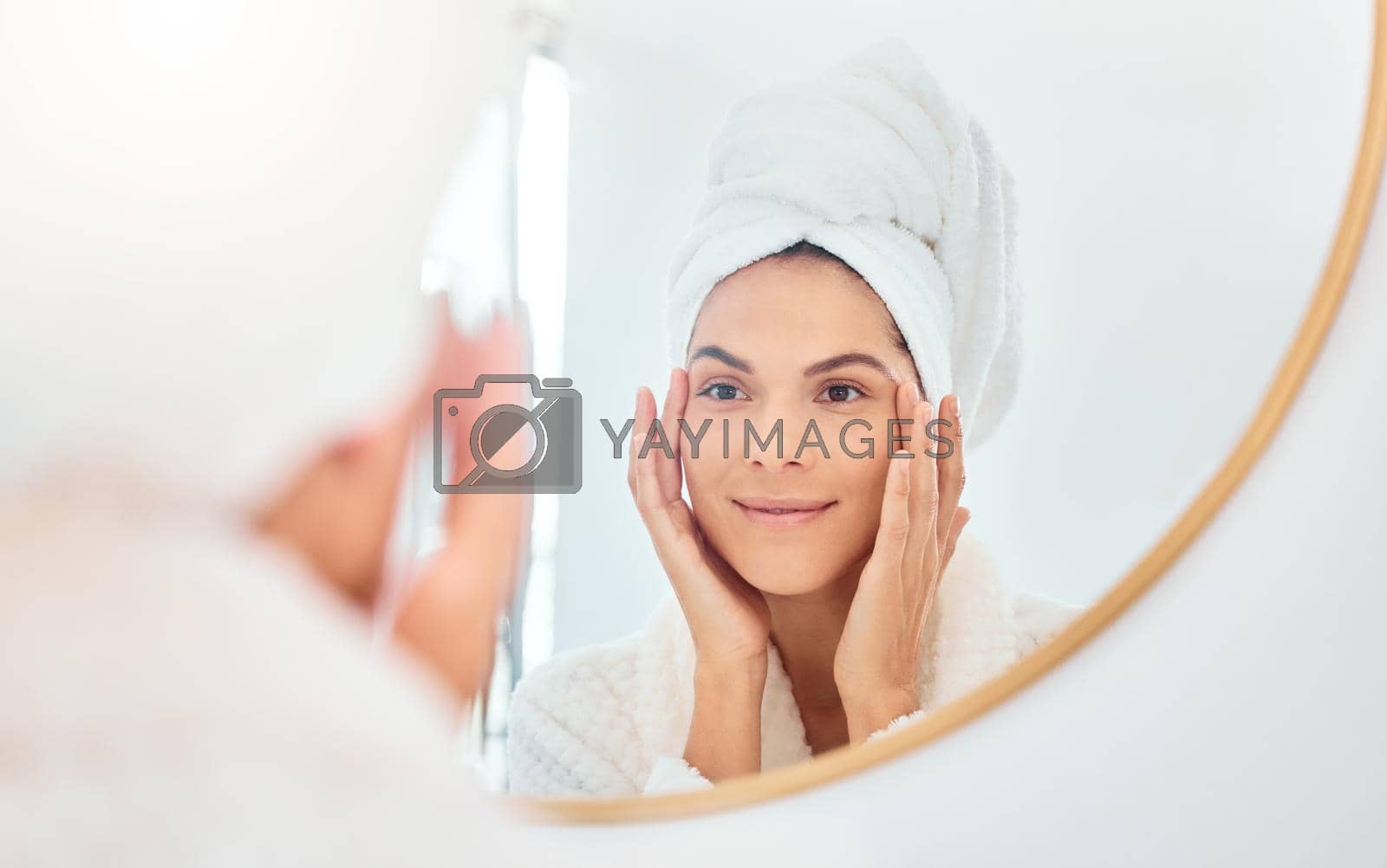 Royalty free image of Perhaps its time for some botox. a young woman analysing her reflection in her bathroom mirror. by YuriArcurs
