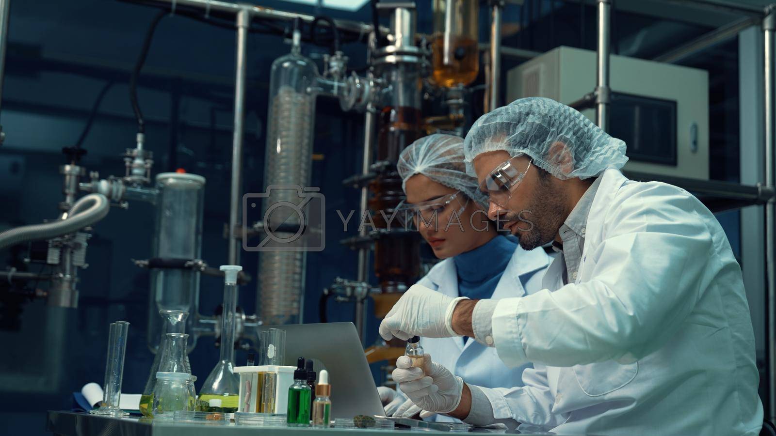 Royalty free image of Two scientist in professional uniform working in laboratory by biancoblue