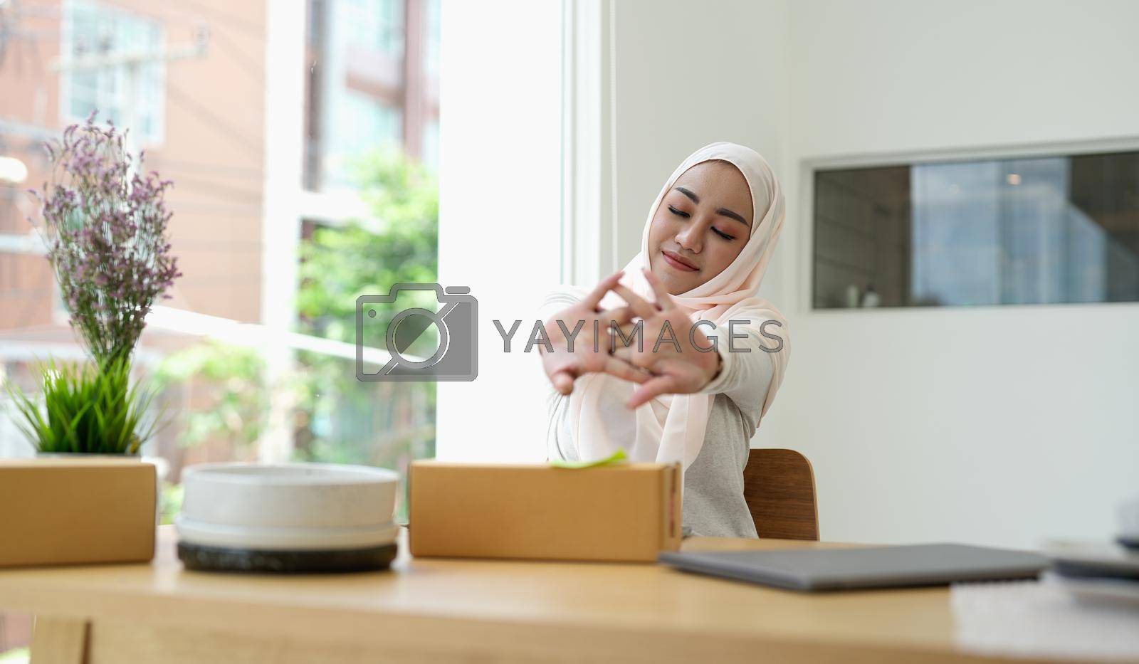 Royalty free image of Relaxing asian muslim woman small business owner at home. by nateemee