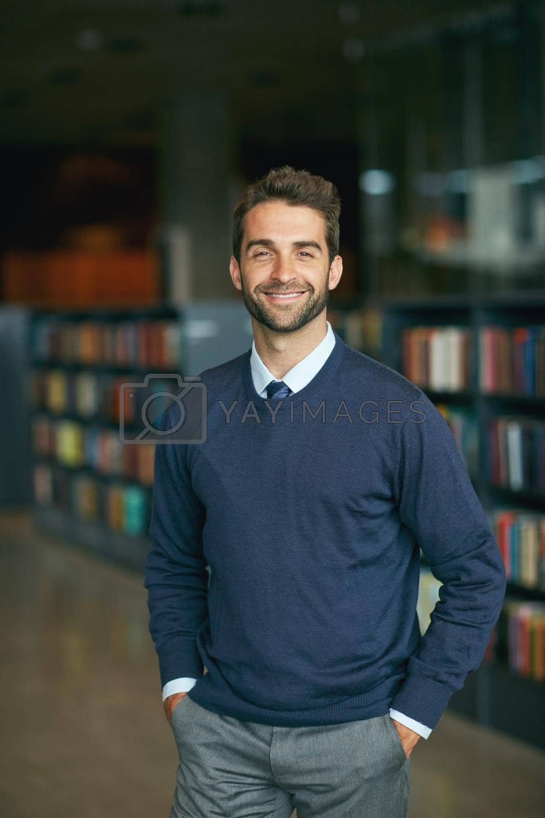 Royalty free image of I work best in libraries. Cropped portrait of a handsome young businessman standing with his hands in his pockets in an empty library. by YuriArcurs