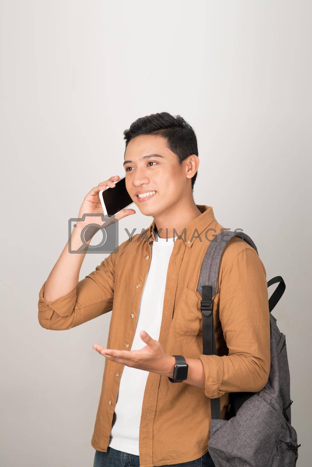 Royalty free image of A handsome Asian student taking on cell phone isolated on white background by makidotvn