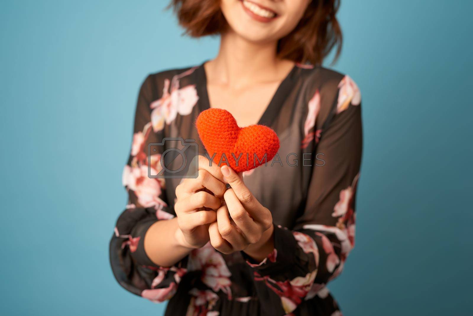 Royalty free image of Valentines day woman holding a heart in front of her by makidotvn