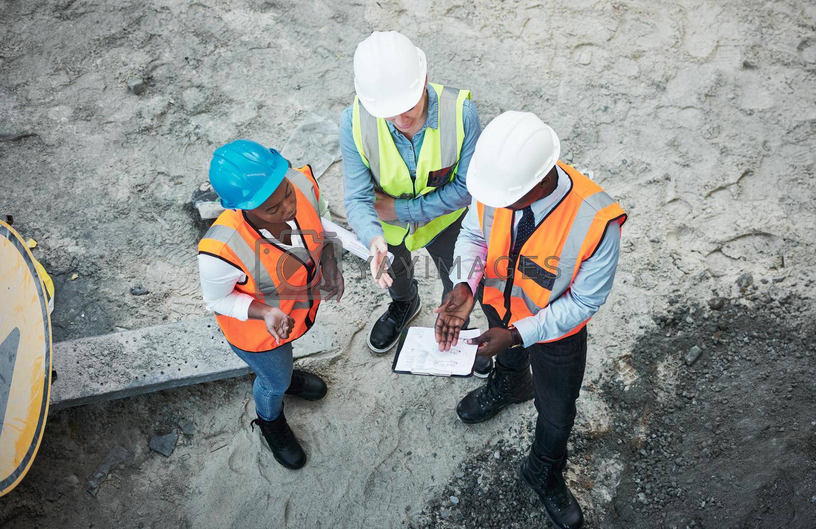 Royalty free image of The hardest work happens out in the field. a group of builders going over building plans at a construction site. by YuriArcurs