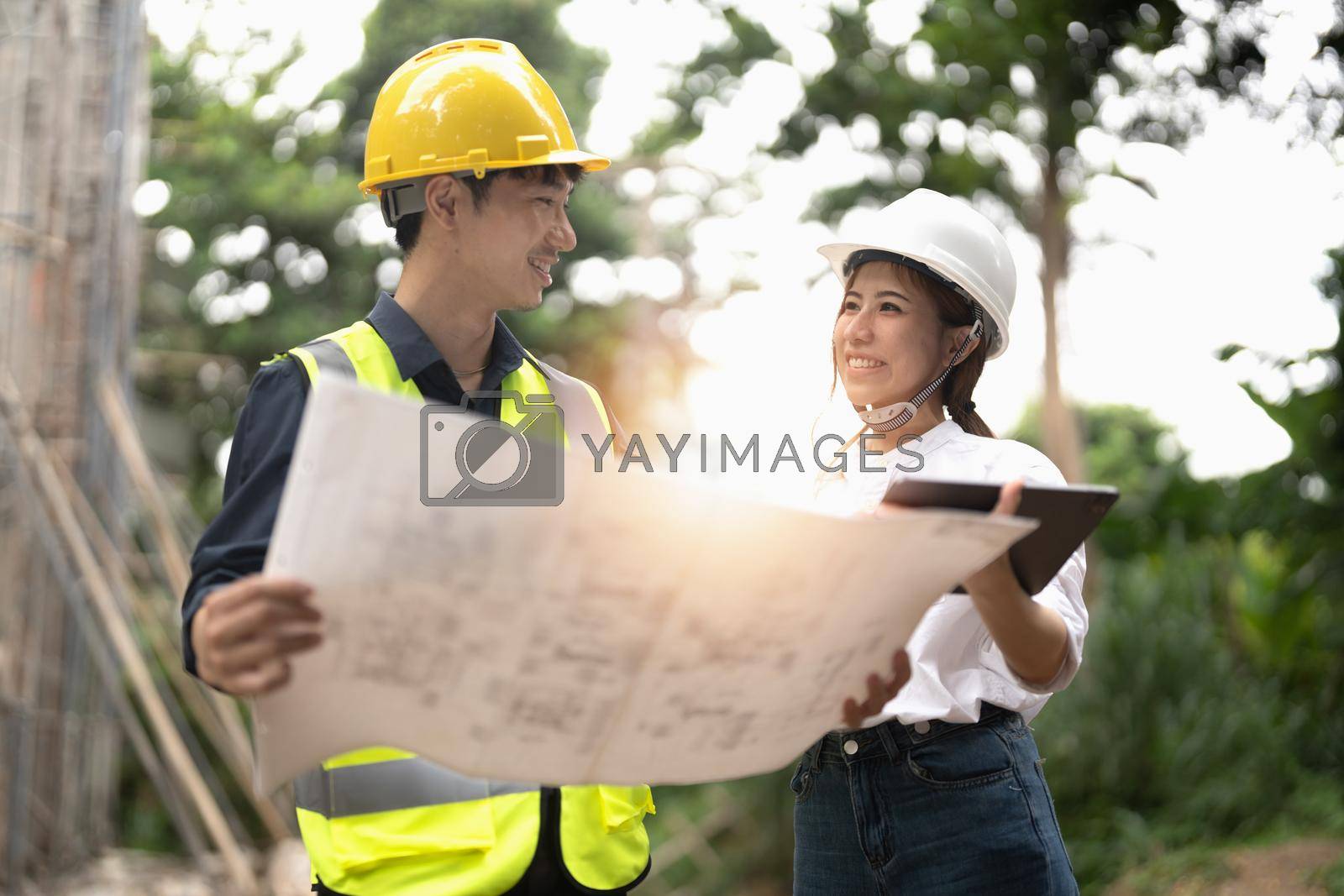 Royalty free image of engineering and construction managers discussing project blue print on the table at construction site by nateemee