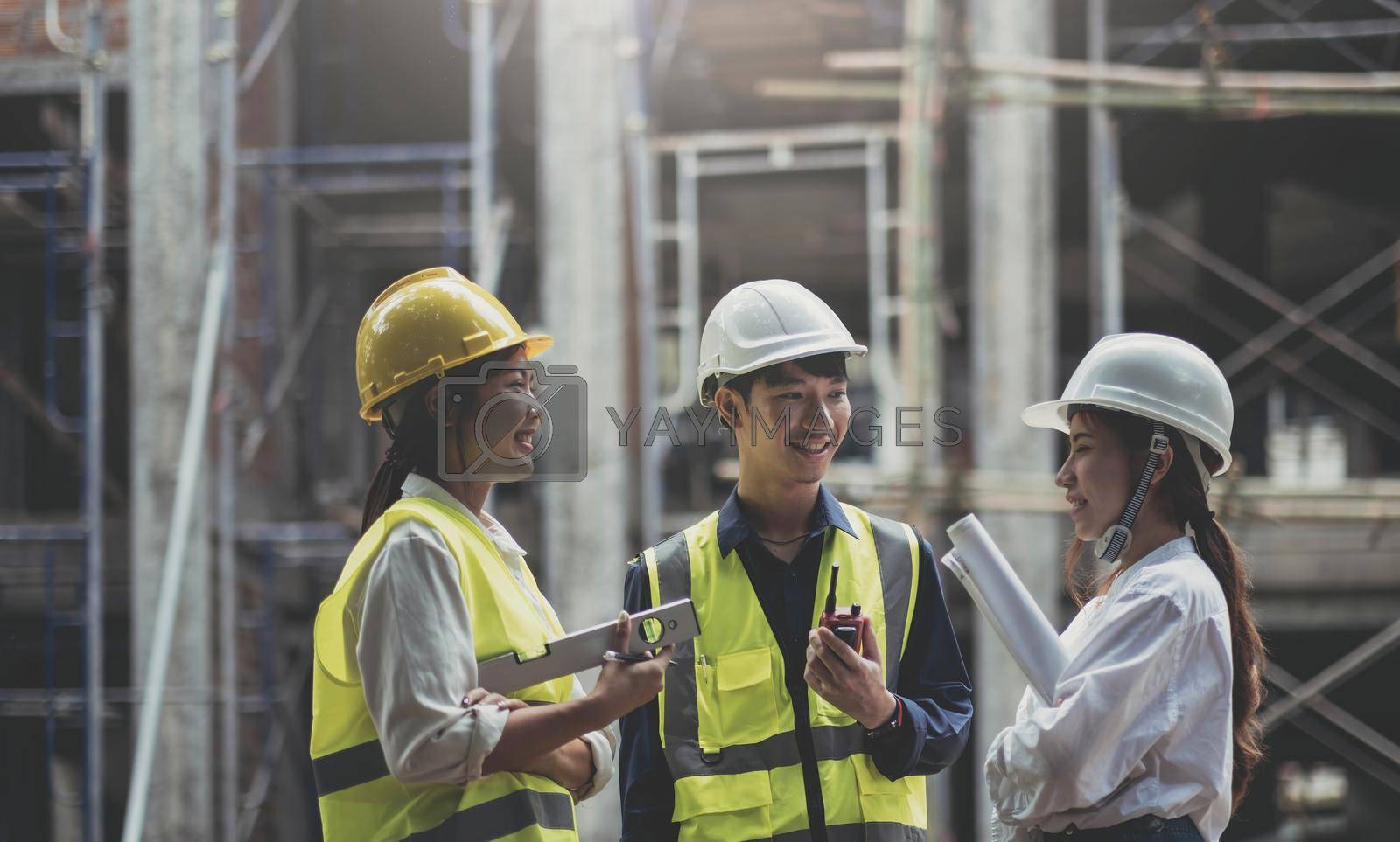 Royalty free image of Professional Construction and Engineer team Working on workplace. Professional black architect and construction worker working look at blueprint plan on site. by wichayada
