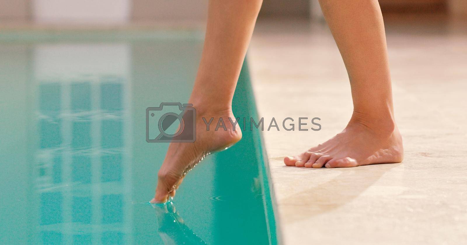 Royalty free image of Testing the waters. an unrecognizable woman sticking her foot in a pool. by YuriArcurs