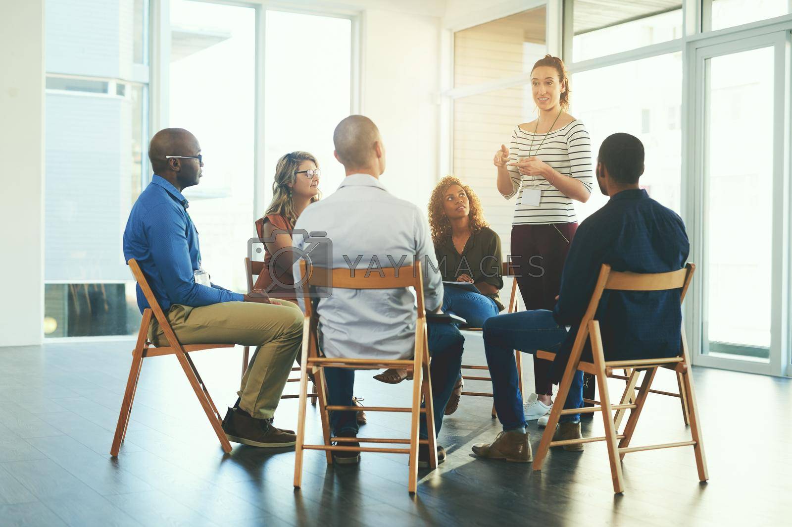 Royalty free image of Female manager or CEO talking in a teamwork meeting about team development and success. Group of marketing team talking about a work strategy together in a coaching or training seminar at a company by YuriArcurs