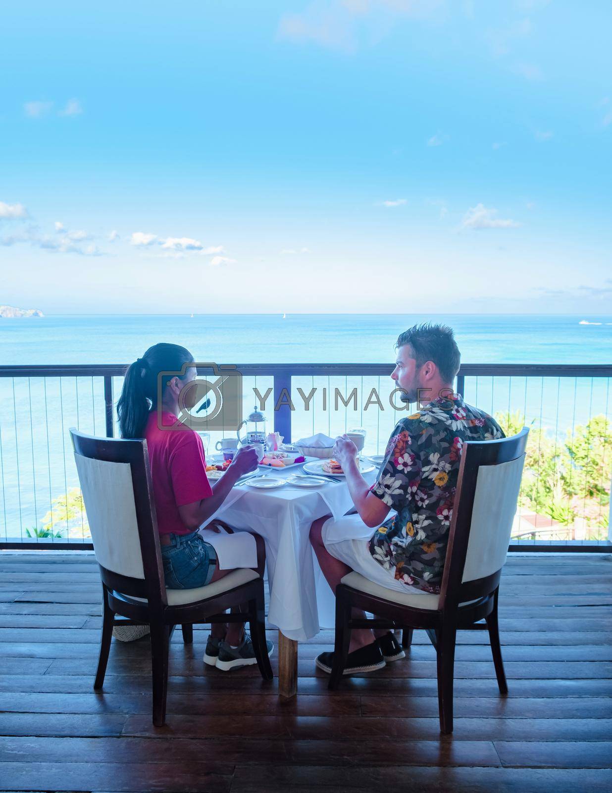 Royalty free image of couple men and women having breakfast with a look over the ocean of Saint Lucia Caribbean by fokkebok