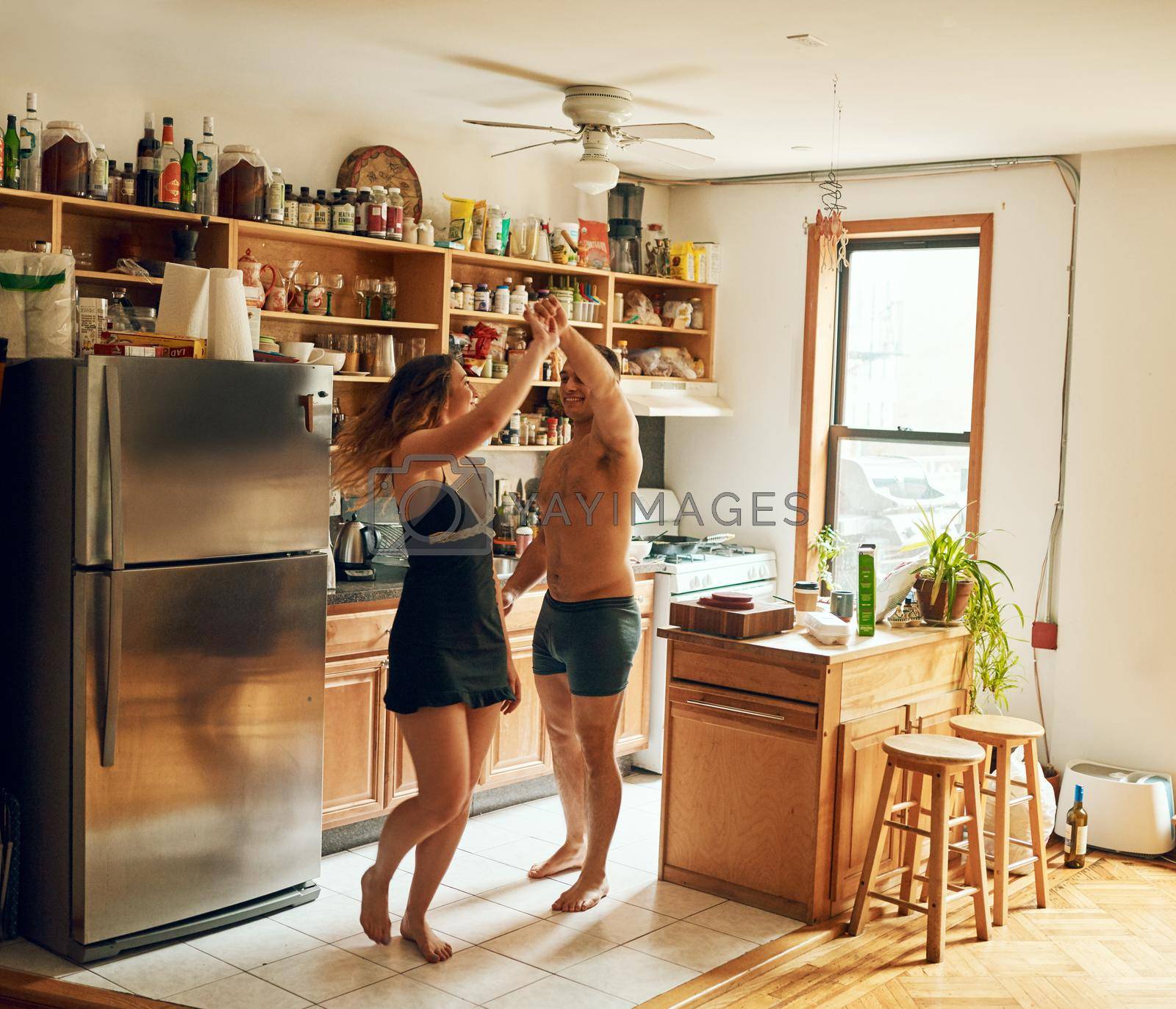 Romance puts the soul into a home. a happy young couple dancing in the kitchen at home