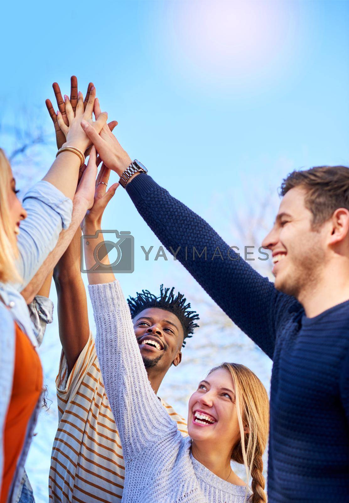 Royalty free image of Time to celebrate passing the year. university students standing outside with their hands together. by YuriArcurs