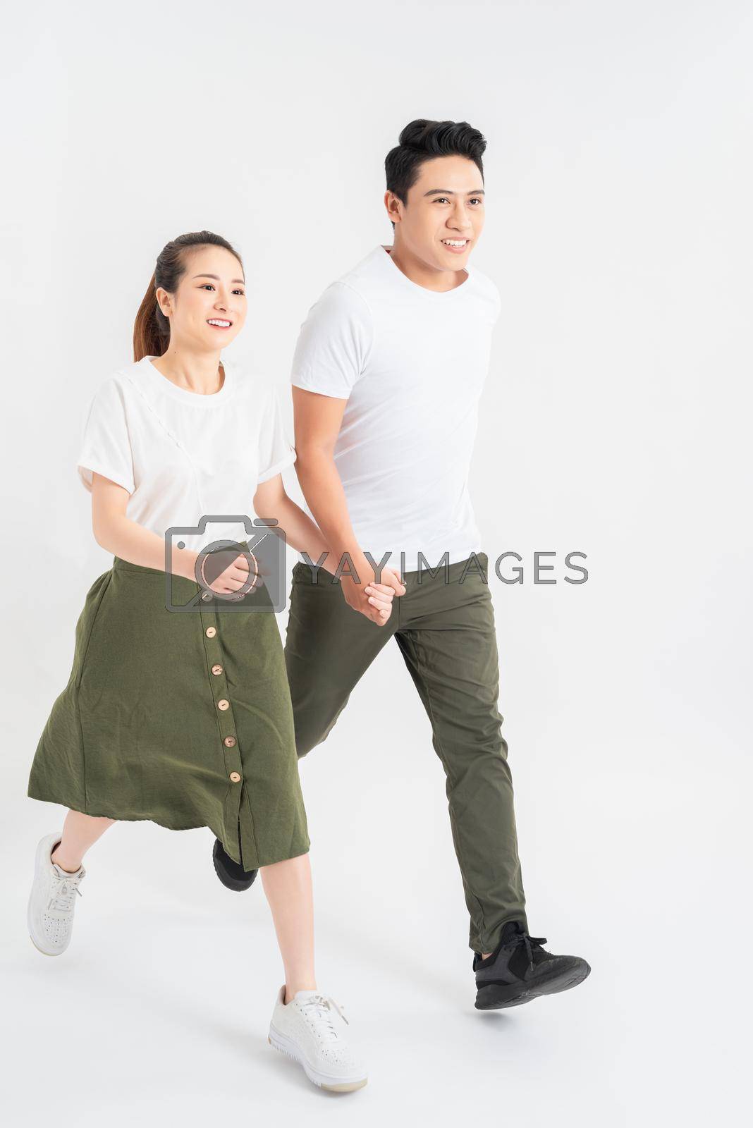 Royalty free image of Young couple in casual clothes walking on white background by makidotvn