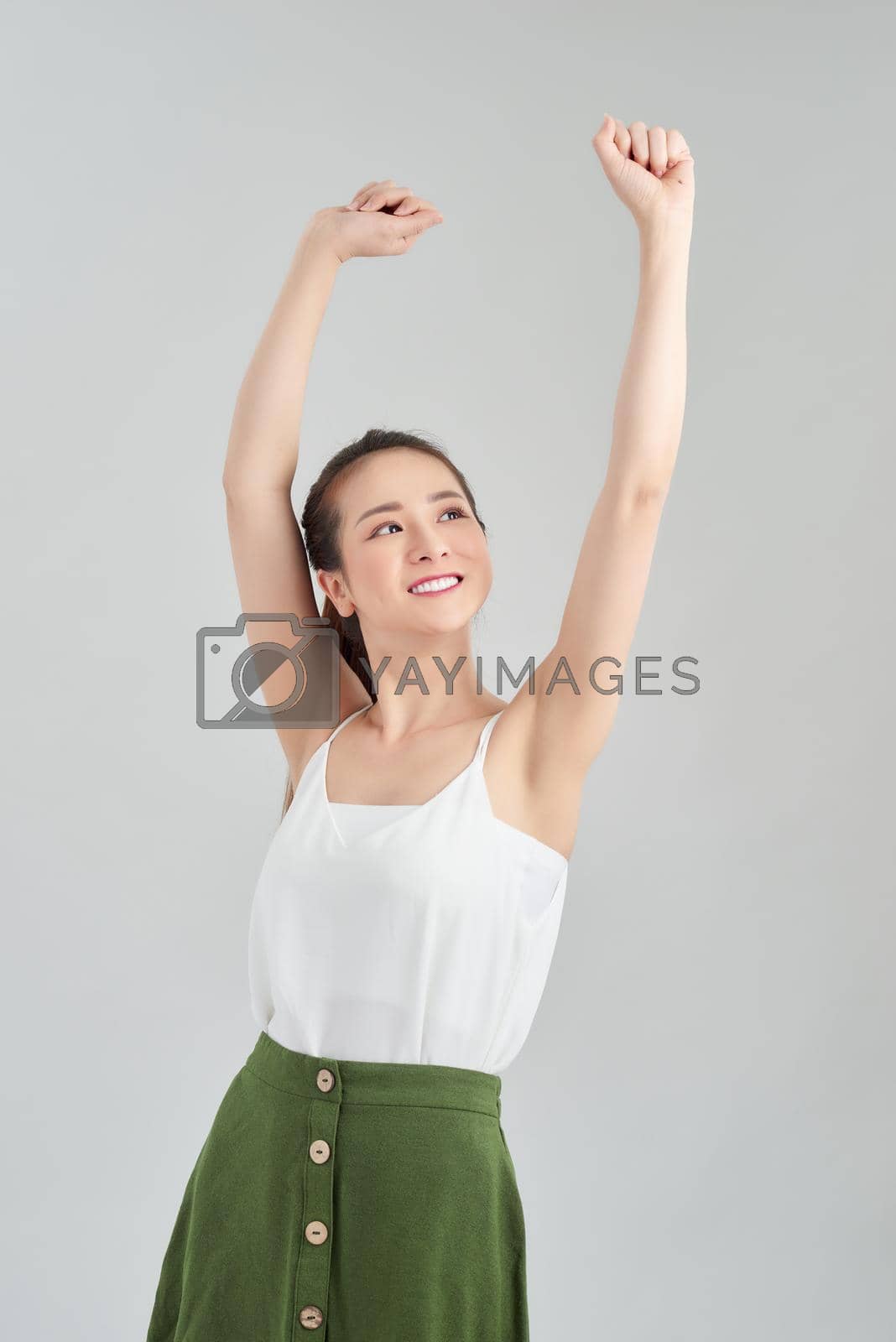 Royalty free image of Attractive young Asian woman relaxing and dancing over white background. by makidotvn
