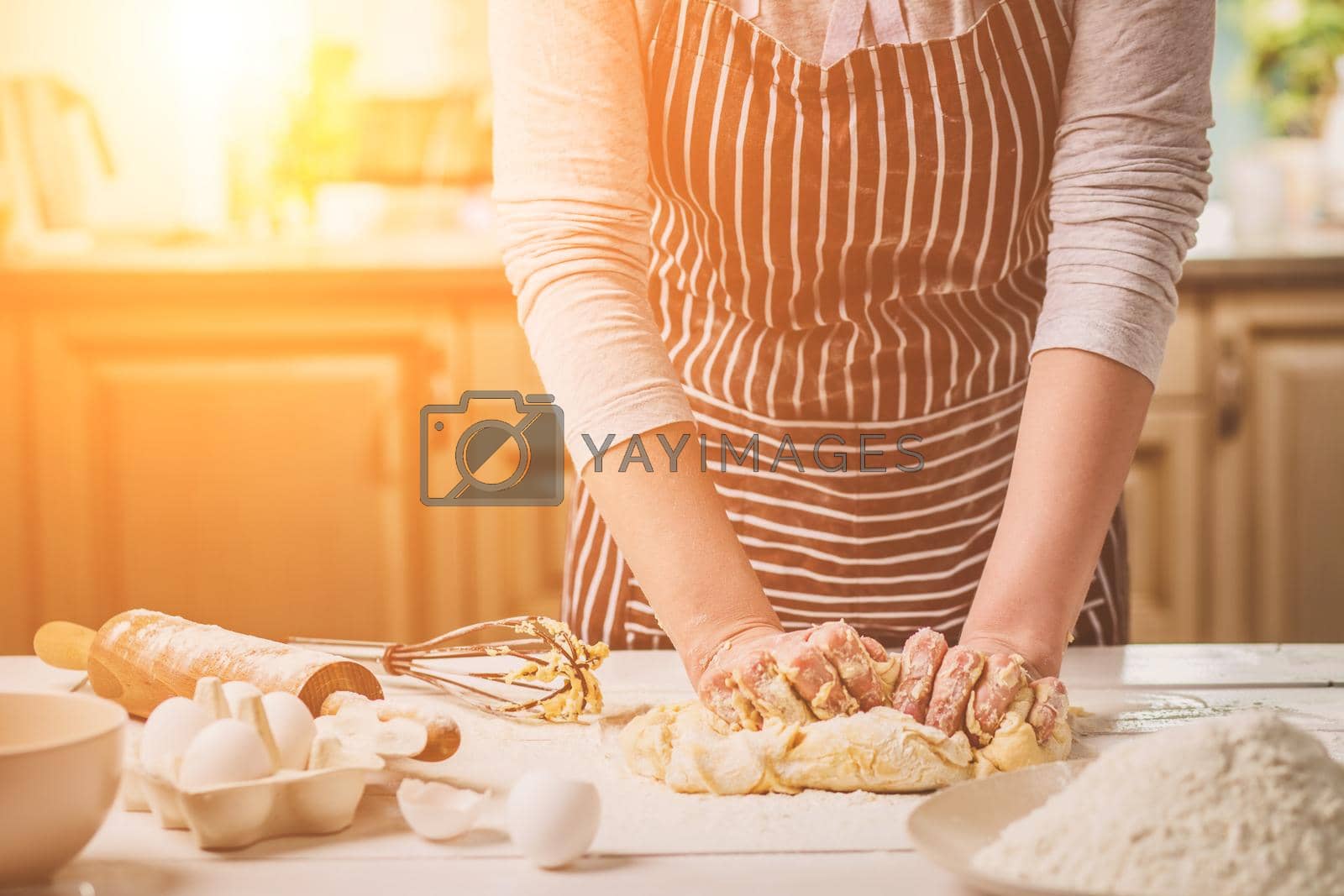 Royalty free image of Woman hands kneading dough on kitchen table by nazarovsergey