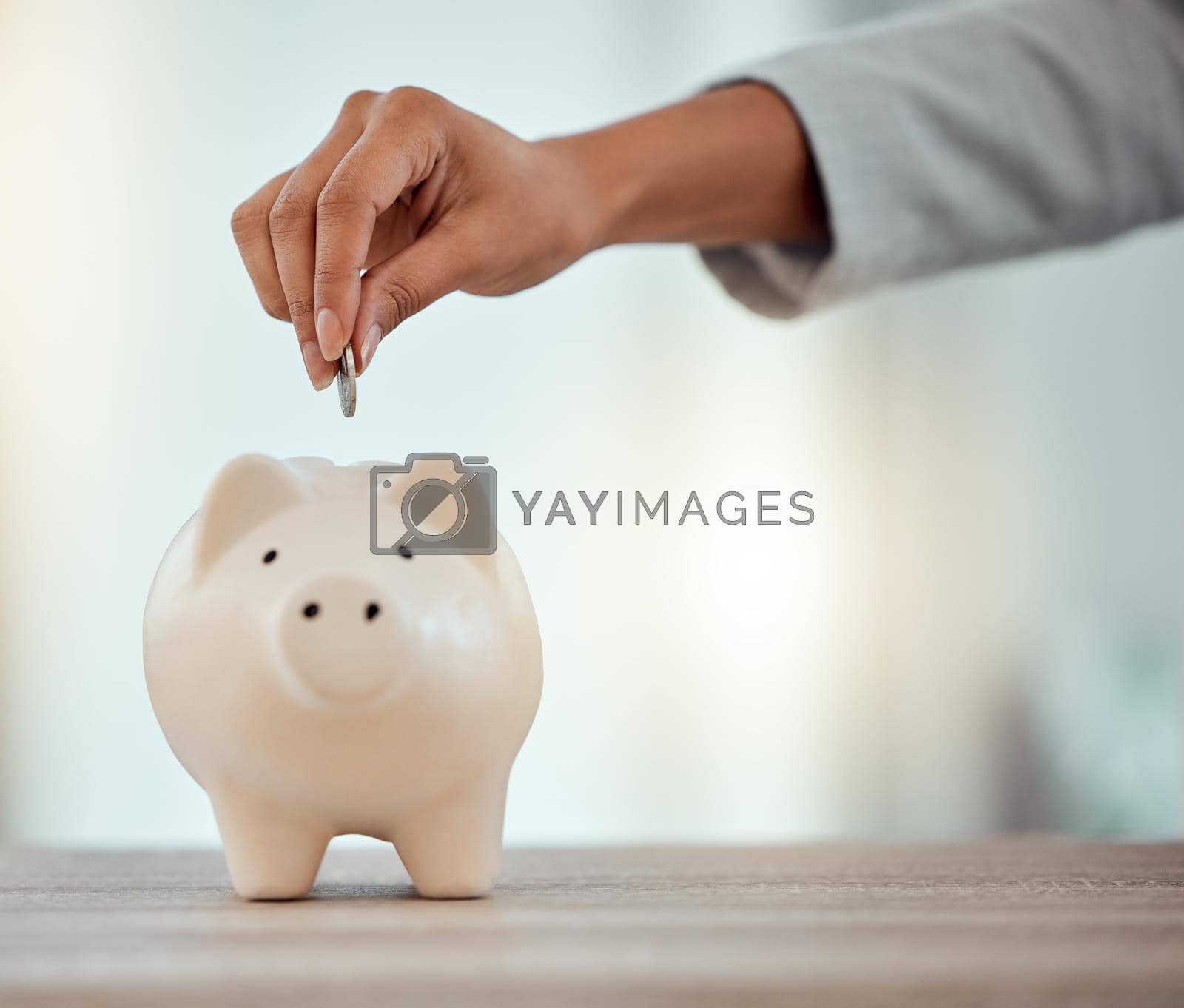 Royalty free image of Savings, investment or hand putting a coin into a piggy bank to save for future growth and financial freedom. Closeup of a female hand dropping or investing money into a retirement fund container by YuriArcurs