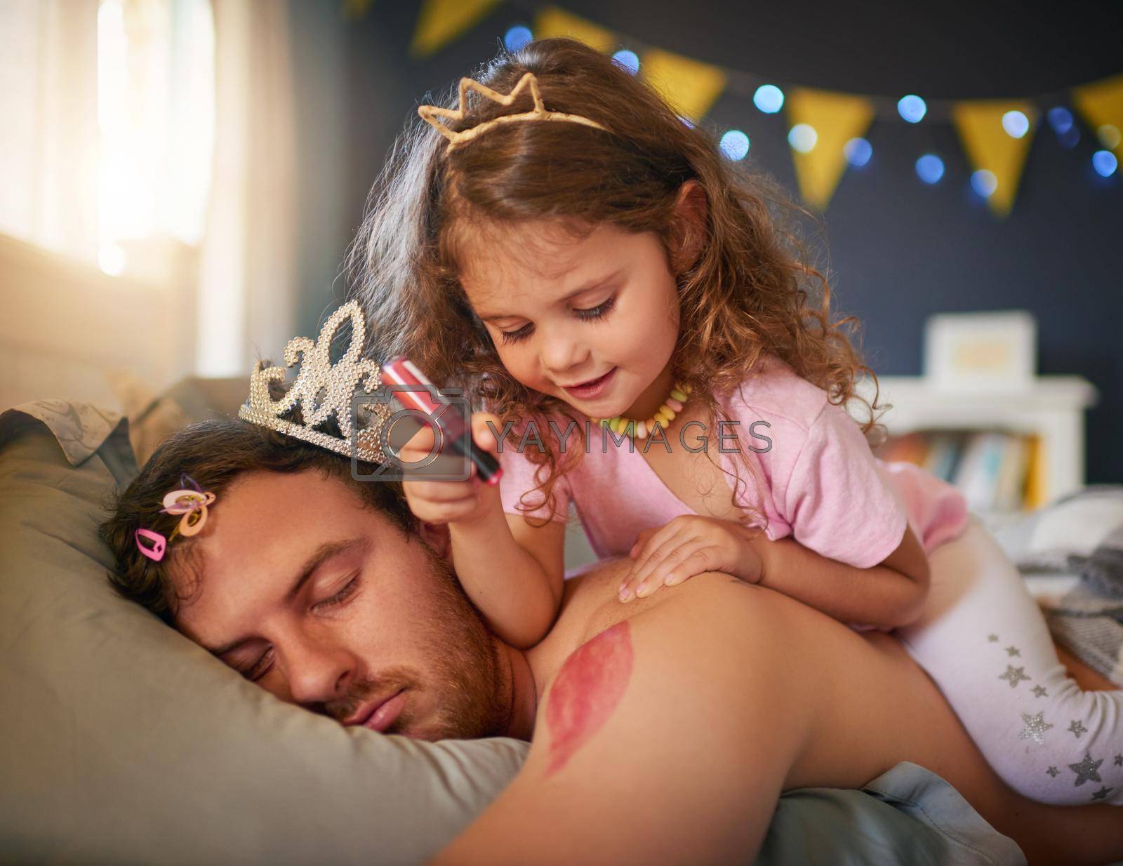 Royalty free image of Shes an artist and Dads the canvas. an adorable little girl drawing with lipstick on her fathers arm while he sleeps. by YuriArcurs