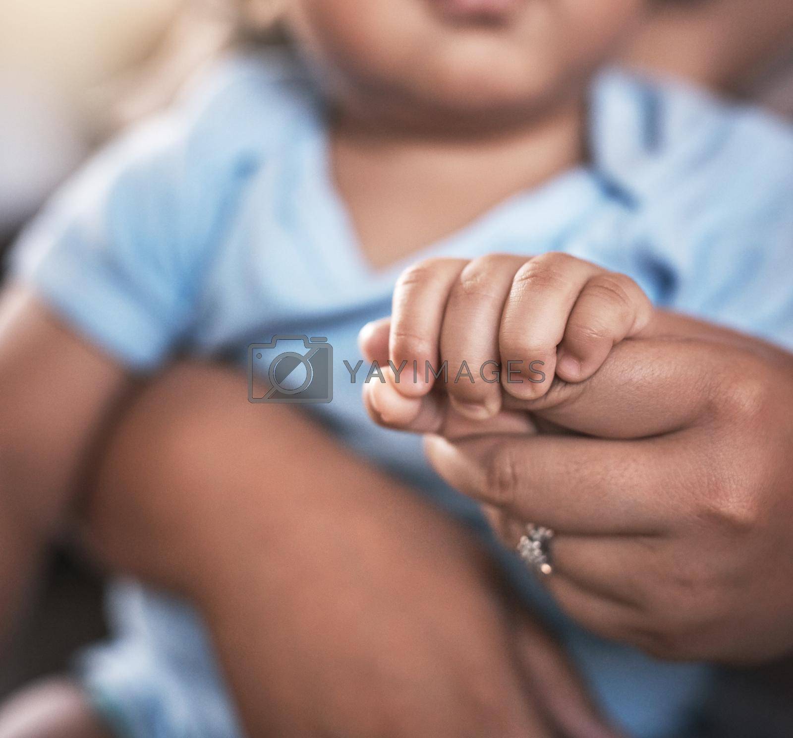 Royalty free image of Tiny hands that bring great love. Closeup shot of a mother holding her baby boys hands at home. by YuriArcurs
