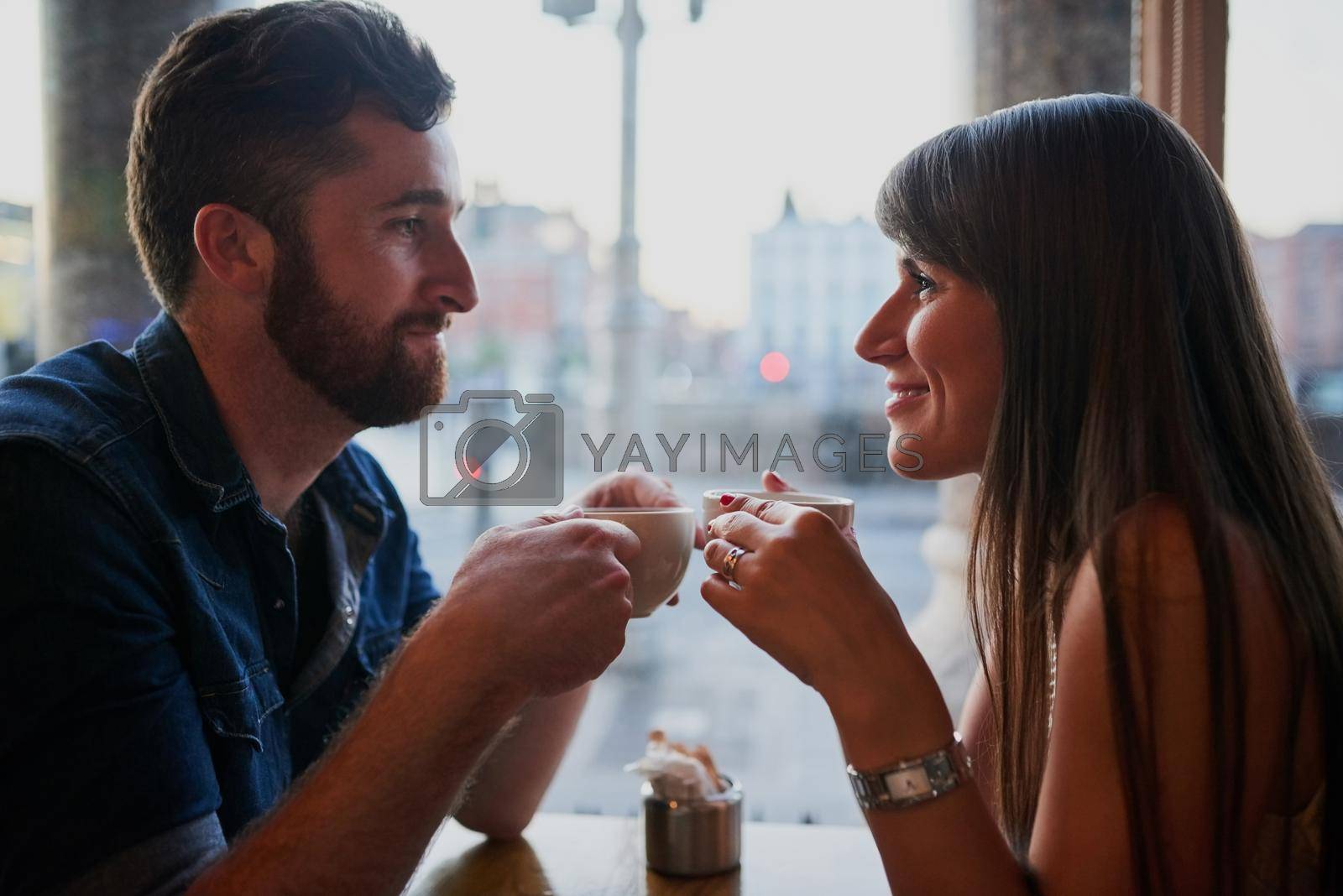 Royalty free image of This is the same coffee shop where they first met. an affectionate young couple sitting in a coffee shop while on a date. by YuriArcurs