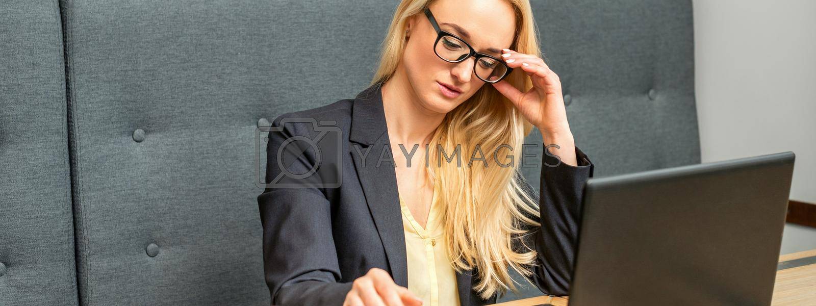 Royalty free image of Young businesswoman using laptop in cafe by okskukuruza