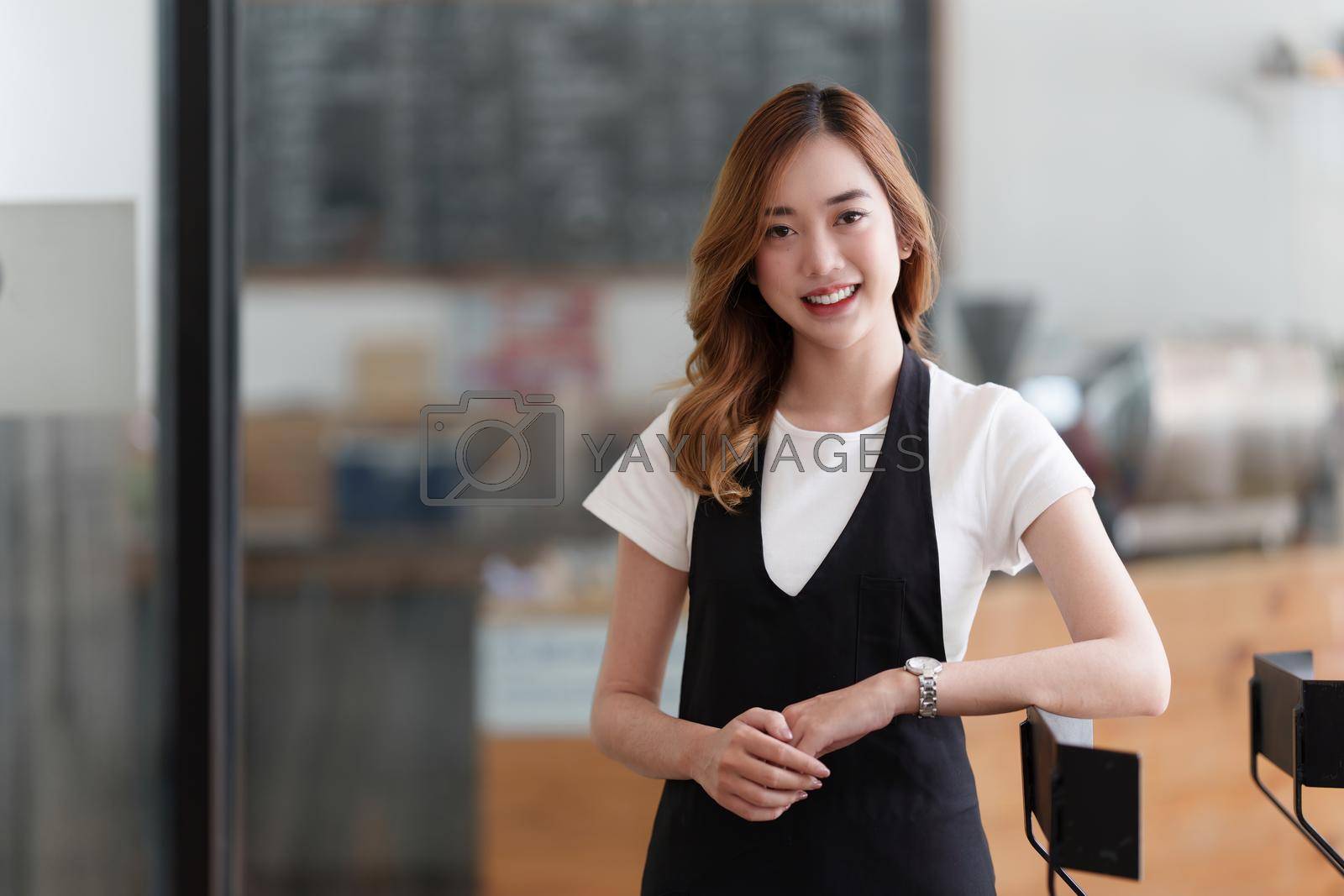 Royalty free image of Beautiful Asian women Barista smiling at her cafe waiting for customer by itchaznong