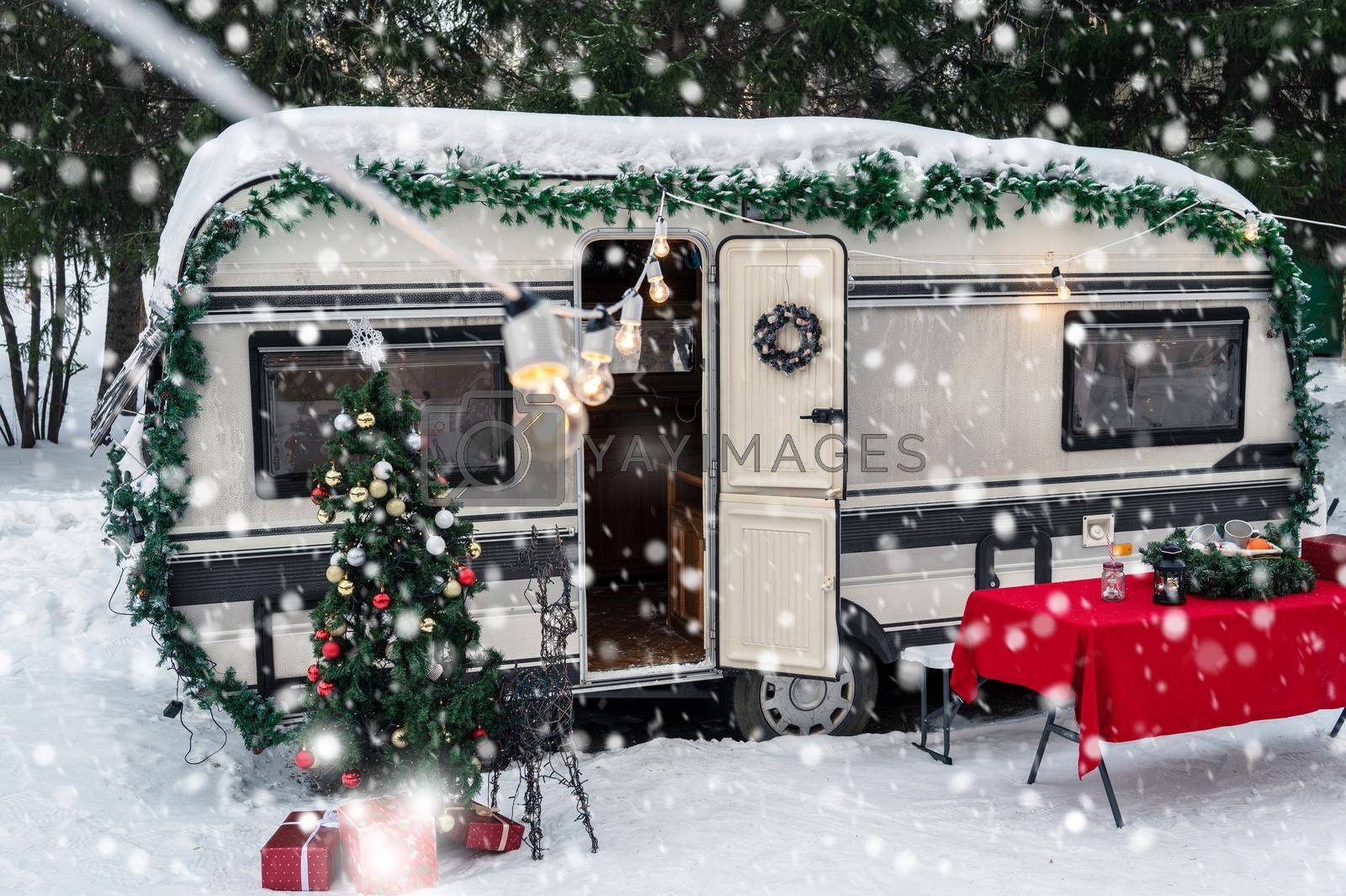 Campervan motorhome in winter camping decorated for Xmas or Happy New Year holiday
