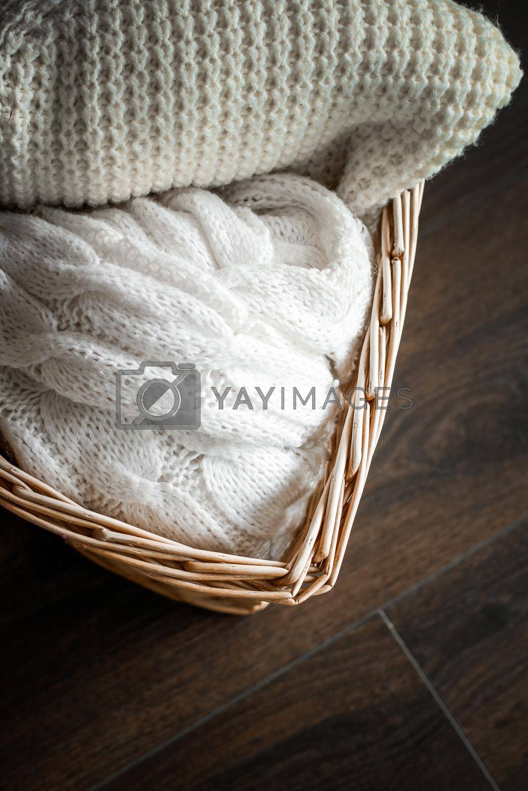 Royalty free image of Knitted winter clothes in a basket by Anneleven