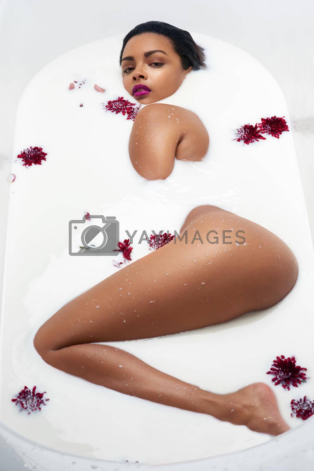 Royalty free image of Pure indulgence. Portrait of a beautiful young woman submerged in white liquid in a bathtub. by YuriArcurs