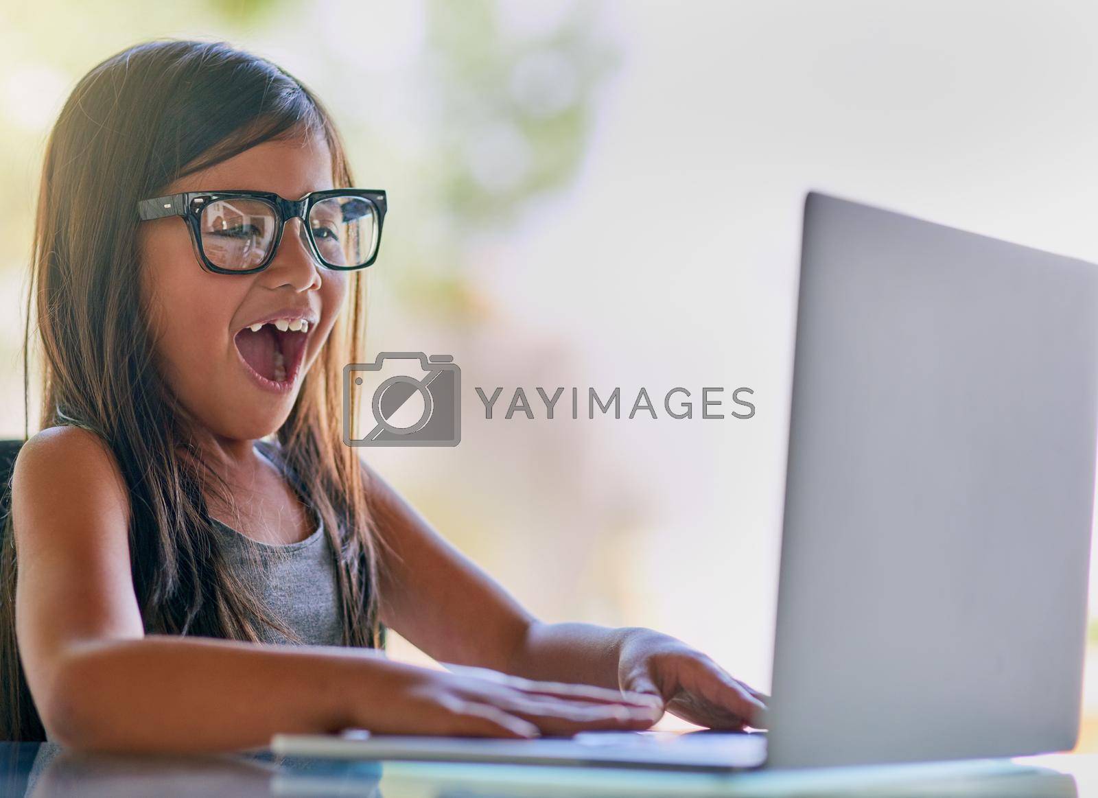 Royalty free image of This is so cool. a little girl looking excited while using a laptop. by YuriArcurs