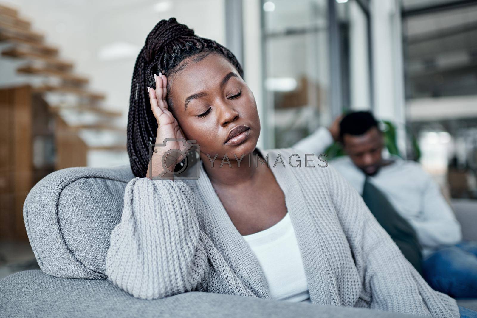 Royalty free image of Sad, frustrated and tired woman ignoring husband during a fight, argument and conflict about divorce, breakup and relationship problems. Unhappy, stressed and depressed wife feeling sad in a marriage by YuriArcurs