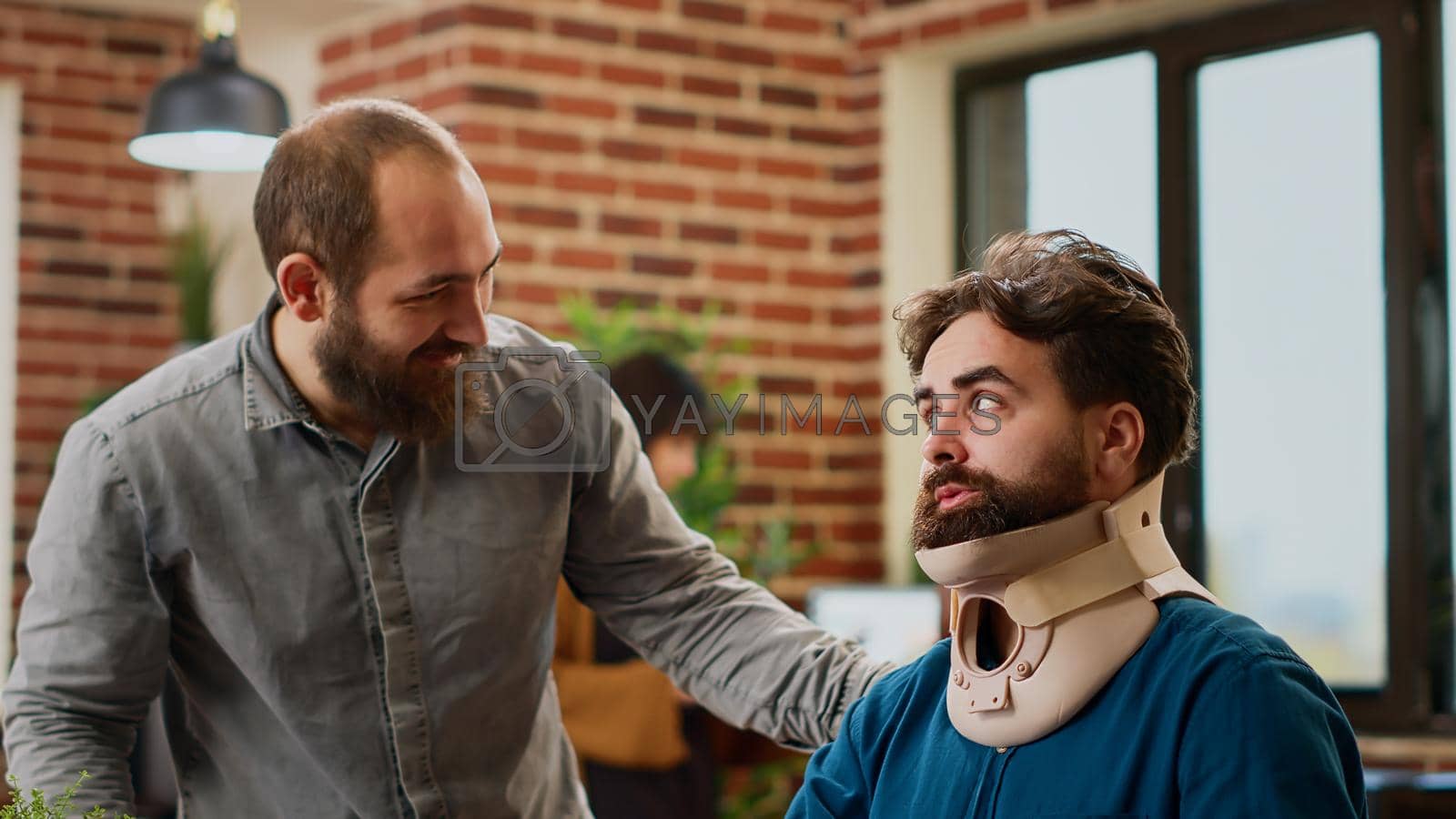 Royalty free image of Office employee with neck collar brace working after accident injury by DCStudio