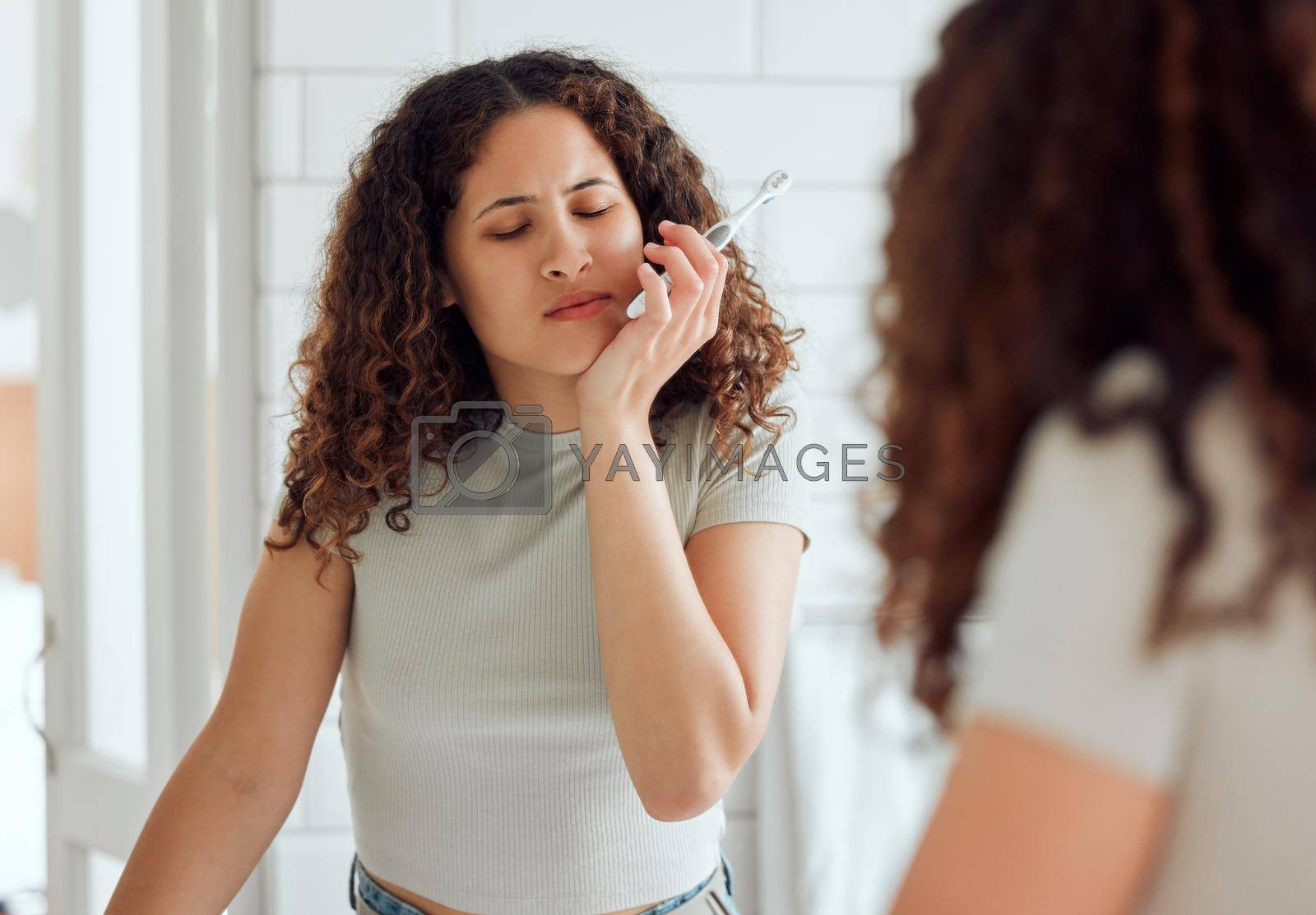 Royalty free image of Toothache, oral pain and dental sensitivity for a woman brushing her teeth in the morning. African American female suffering with a painful, hurting or inflammation in her mouth in the bathroom by YuriArcurs