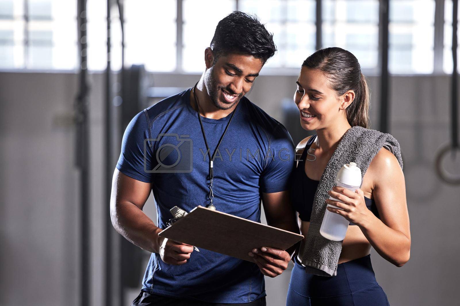 Royalty free image of Gym subscription, personal trainer and happy client talking and ready to fill in a membership form. Fitness coach discussing training, workout plan and progress in a health and wellness facility by YuriArcurs