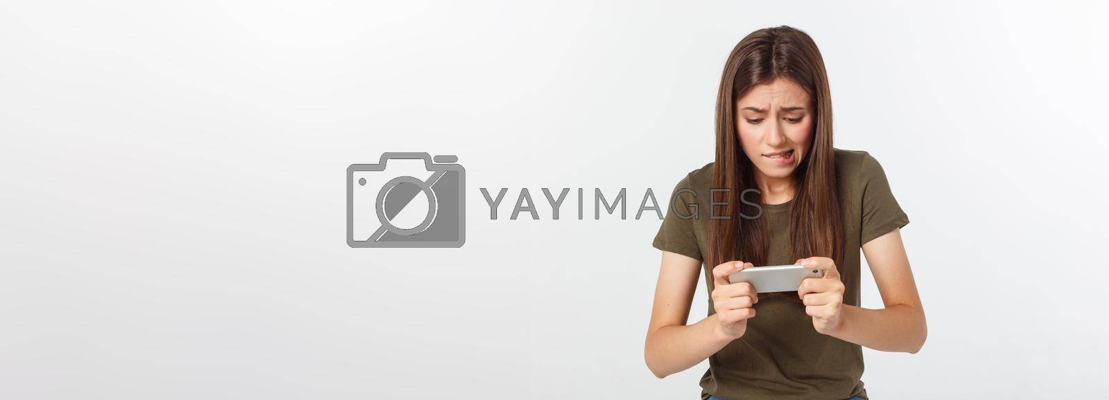 Royalty free image of Happy attractive brunette girl joying win in video game on smartphone, isolated over grey background by Benzoix
