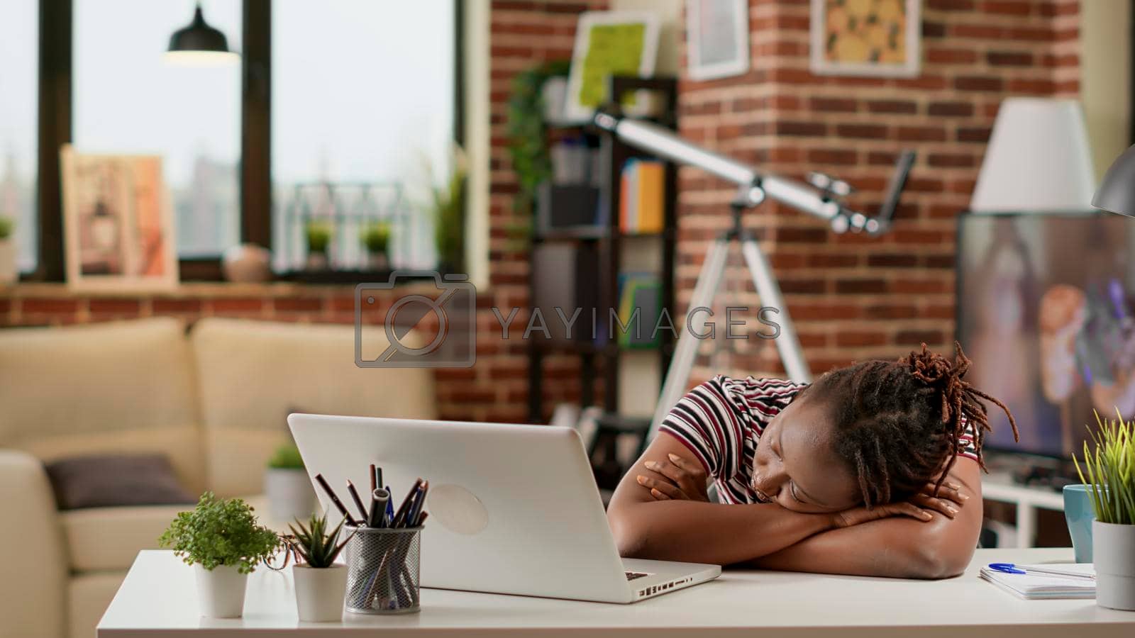 Royalty free image of Tired stressed employee falling asleep on desk at remote work by DCStudio