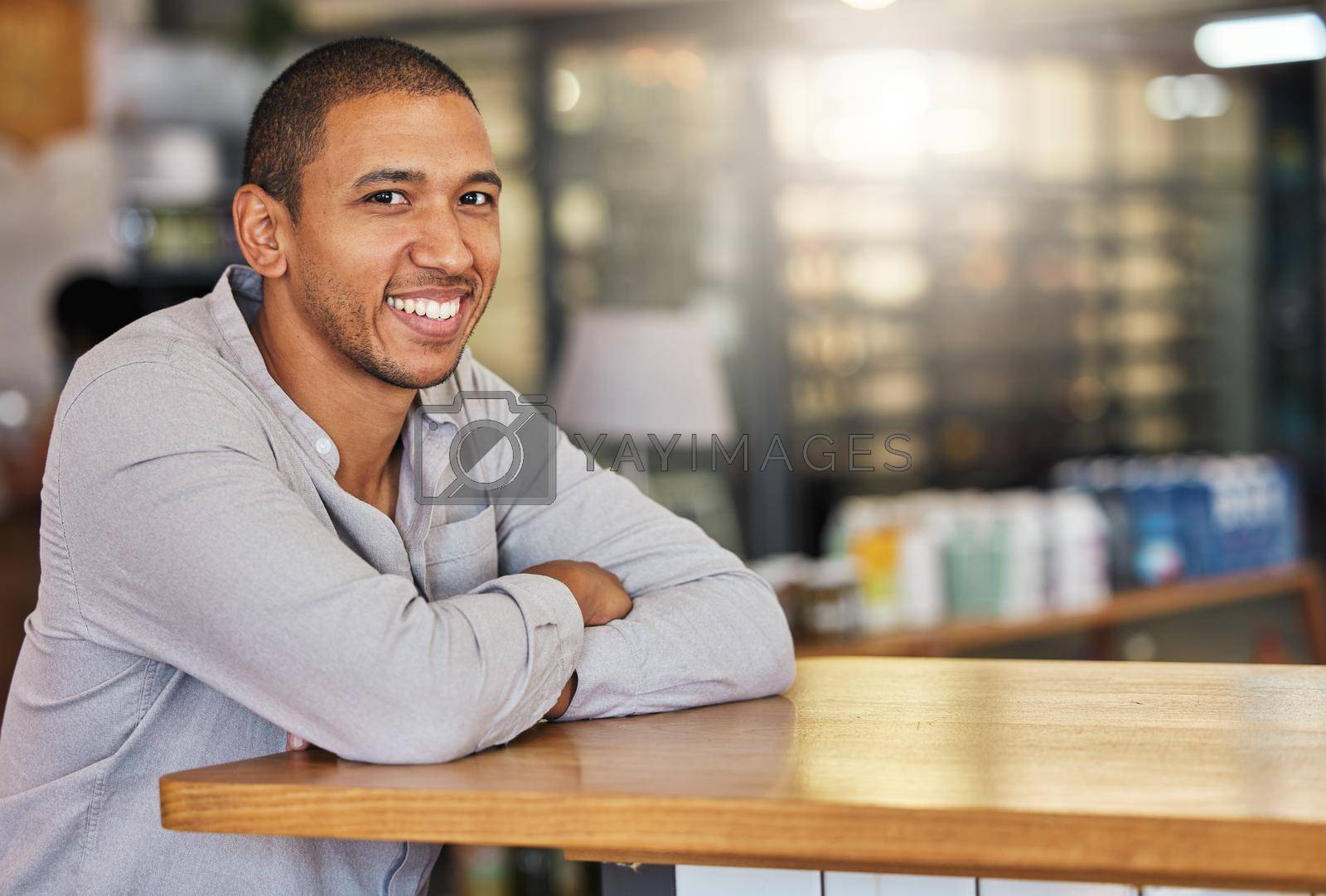 Royalty free image of Entrepreneur or small business owner of cafe or coffee shop at counter happy and smiling. Young, confident and successful boss, manager or leader of a hospitality startup restaurant, bistro or store by YuriArcurs