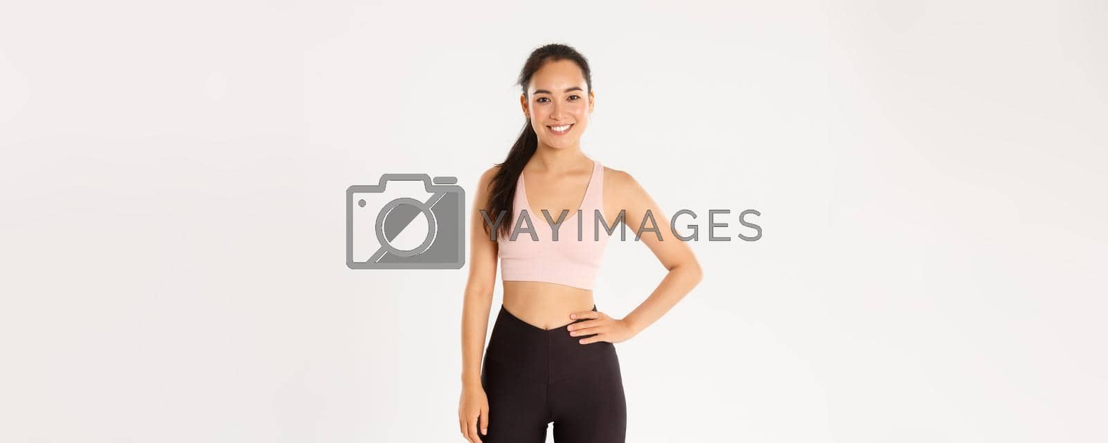 Royalty free image of Sport, wellbeing and active lifestyle concept. Cheerful smiling asian girl promote you logo gym, special discount for membership or online classes app to workout from home, white background by Benzoix