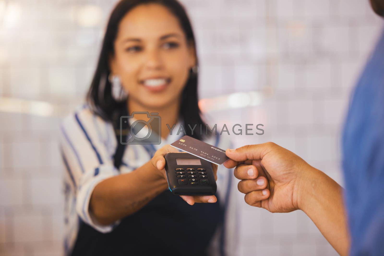 Royalty free image of Credit card, payment and customer with an electronic reader in the hand of a cashier to process a fintech purchase or money spend. Consumer making a banking or finance transaction in a coffee shop by YuriArcurs