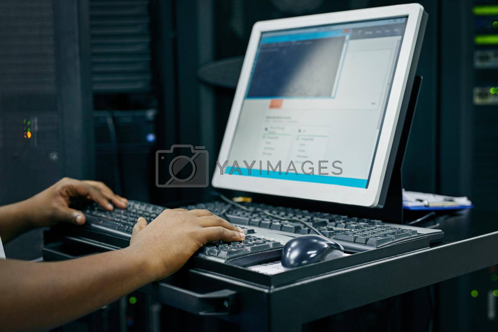 Royalty free image of Your computer network in expert hands. an IT technician using a computer while working in a data center. by YuriArcurs