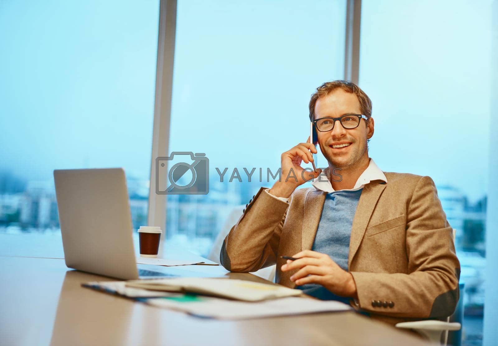 Royalty free image of Its always a pleasure to hear from you. a handsome male designer working at his desk in the office. by YuriArcurs